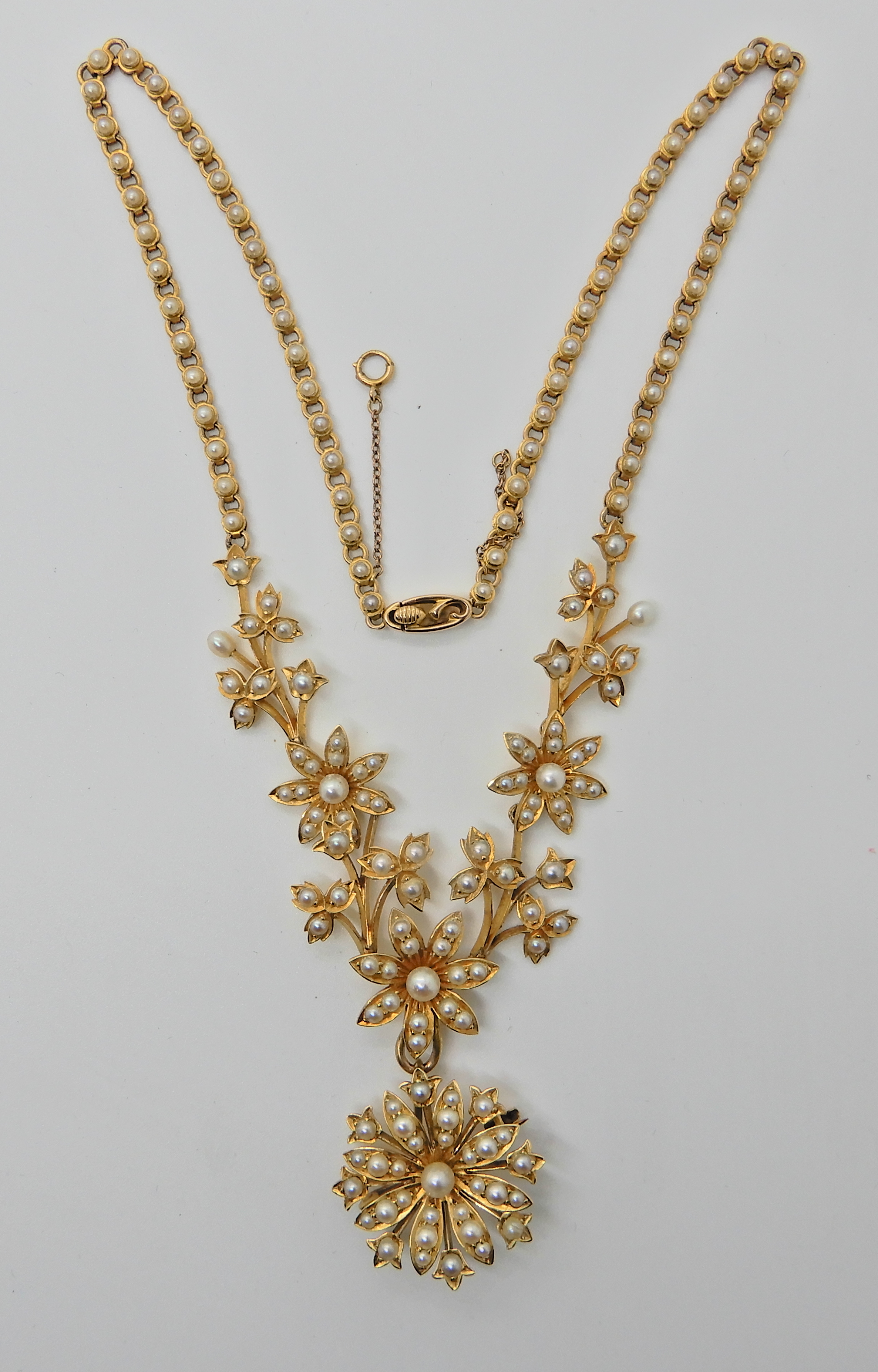 A 15ct gold floral pearl set necklace with detachable brooch, the chain is also set along its length