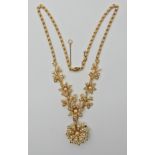 A 15ct gold floral pearl set necklace with detachable brooch, the chain is also set along its length