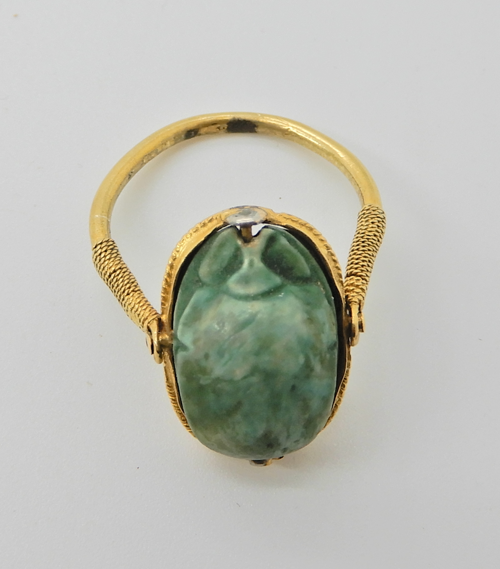 An Arabic gold ring set with a turquoise glazed ceramic scarab possibly of the antique in modern