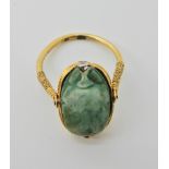 An Arabic gold ring set with a turquoise glazed ceramic scarab possibly of the antique in modern