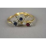 A three stone ruby and diamond ring, the shank stamped '18ct',