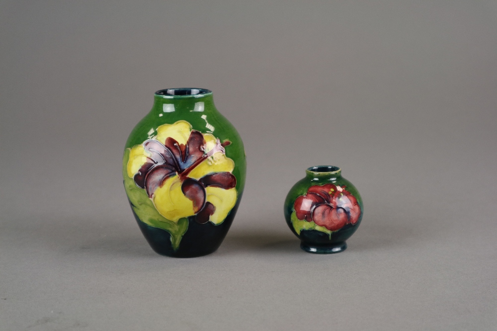 A Moorcroft vase in the Hibiscus pattern against a green ground, 9cm high,