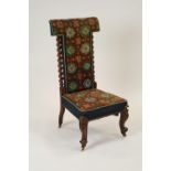 A Victorian rosewood prie-dieu with geometric tapestry panel back and over stuffed seat raised on