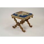 A Victorian walnut X-framed stool with floral tapestry tasseled top