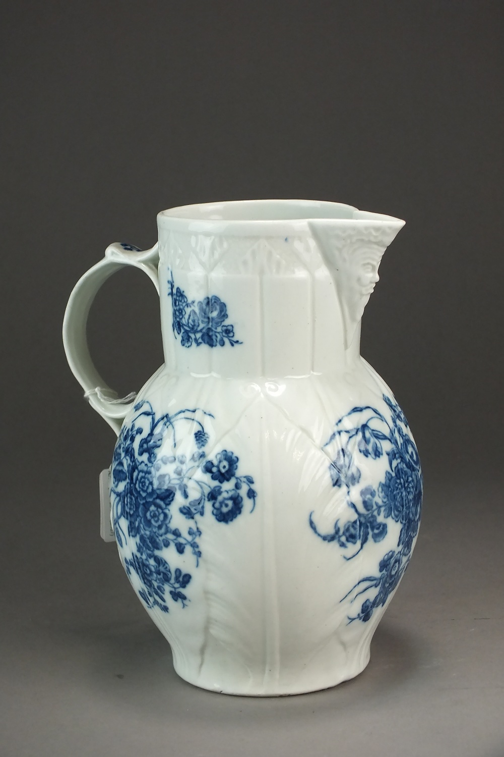 A Caughley mask head cabbage leaf jug transfer-printed in the Three Flowers pattern, circa 1785,