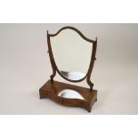 A George III mahogany and satinwood strung serpentine front toilet mirror with shield shaped plate