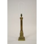 A gilt metal ionic column table lamp on stepped square plinth fitted for electricity,