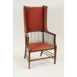 An Edwardian mahogany and box wood strung wing back armchair in Arts and Crafts style,