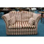 A Knowle style two seater settee upholstered in cream and pink brocade fabric