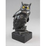 A bronze of an owl, early 20th century, naturalistically modelled and with yellow glass eyes,