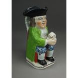 A Staffordshire pearlware toby jug, early 19th century, seated and holding a foaming jug,