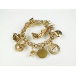 A yellow metal fancy link charm bracelet, with attached yellow metal and gold charms,