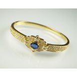 A sapphire and diamond hinged bangle,