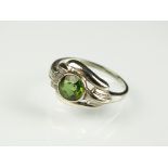 A single green stone ring, collet set in white metal, the shank stamped '14k', ring size N,