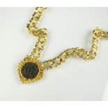 A textured decorative link chain suspending yellow metal mounted coin pendant,