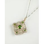 A demantoid garnet, diamond and seed pearl pendant/brooch,