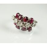 A diamond and ruby dress ring, designed as a central row of five brilliant cut diamonds,