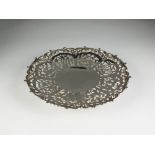 A white metal pierced shallow dish, with bamboo and blossom decoration, raised on collet foot,