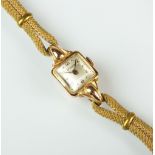 A lady's 18ct gold Bucherer cocktail watch, the oblong silvered dial with Arabic numerals,