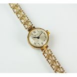 A lady's 9ct gold Marvin Revue bracelet watch, the circular silvered dial with black Roman numerals,