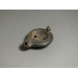 Roman, ceramic oil lamp, 2nd century AD; rounded nozzle with petta pattern to sides, oval body