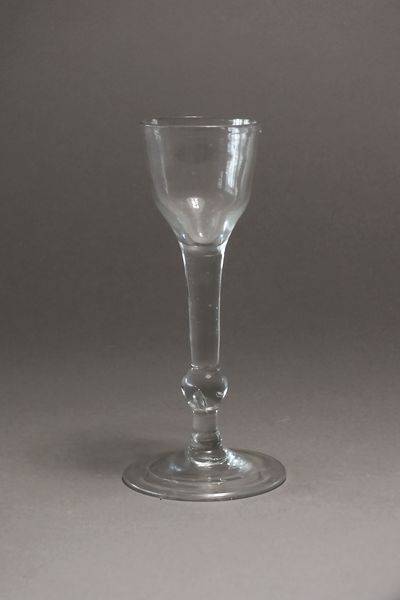 An English drinking glass, circa 1760, with an ogee bowl above a plain stem with a single knop above