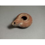 Greek, ceramic oil lamp, 5th century BC. Projecting nozzle with rounded end; bulbous body with