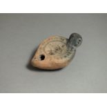 Roman, ceramic oil lamp, 3rd century AD; rounded nozzle with oval body; flat shoulder with beaded