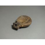 Roman, ceramic oil lamp, 2nd century AD; angled nozzle with petta pattern to either side; oval
