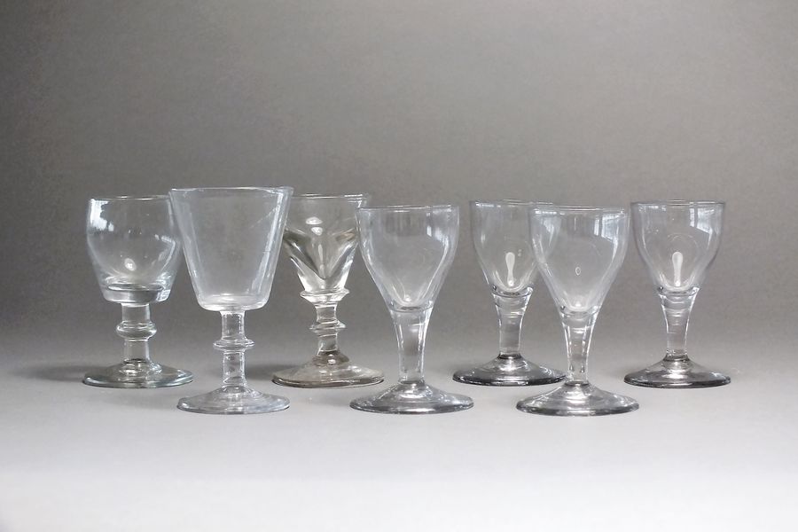 A group of small English drinking glasses, 18th century comprising a deceptive glass, four wines and