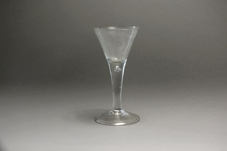 A large English wine glass c.1765 with wide flared trumpet bowl raised above a teardrop knop on a