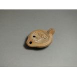 Roman, ceramic oil lamp, 1st - 2nd century AD. Rounded nozzle with oval body, dished top decorated