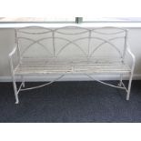 A Regency painted wrought iron garden bench, with shaped openwork back and slat seat grooved arms