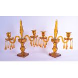 A STYLISH PAIR OF ANTIQUE BOHEMIAN SMOKEY AMBER GLASS CANDLEABRA with facetted stems, upon square