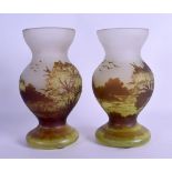 A PAIR OF CONTINENTAL CAMEO GLASS VASES in the manner of Galle, decorated with extensive landscapes.