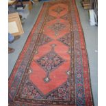 A RED GROUND PERSIAN RUNNER, decorated with motifs. 372 cm x 123 cm.