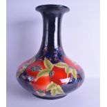 A LARGE MOORCROFT STYLE BULBOUS VASE painted with pomegranate and berries. 41 cm x 30 cm.