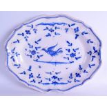 AN EARLY 20TH CENTURY CONTINENTAL FAIENCE SCALLOPED OVAL DISH painted with a bird amongst foliage.