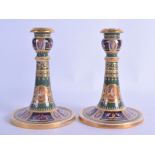 A GOOD PAIR OF EARLY 20TH CENTURY VIENNA PORCELAIN CANDLESTICKS painted with classical figures
