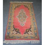 A SMALL RED GROUND PERSIAN RUG, decorated with flowers. 139 cm x 71 cm.