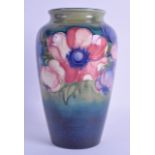 AN ANTIQUE WILLIAM MOORCROFT VASE painted with floral sprays. 21.5 cm high.