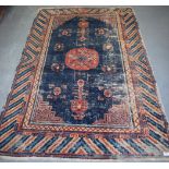 AN ANTIQUE KHOTAN RUG from East Turkestan, blue ground decorated with motifs. 190 cm x 123 cm.