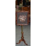 A VICTORIAN CARVED WALNUT POLESCREEN, with embroidered panel depicting flowers. 142 cm.