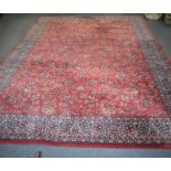 A LARGE RED GROUND PERSIAN CARPET, decorated with foliage. 350 cm x 245 cm.