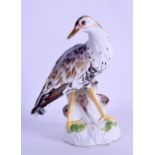 A 19TH CENTURY MEISSEN PORCELAIN FIGURE OF A BIRD modelled in purple enamels upon a naturalistic