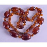 AN ART DECO CARVED ORANGE AMBER NECKLACE. 58 grams. 68 cm long, largest bead 3 cm long.