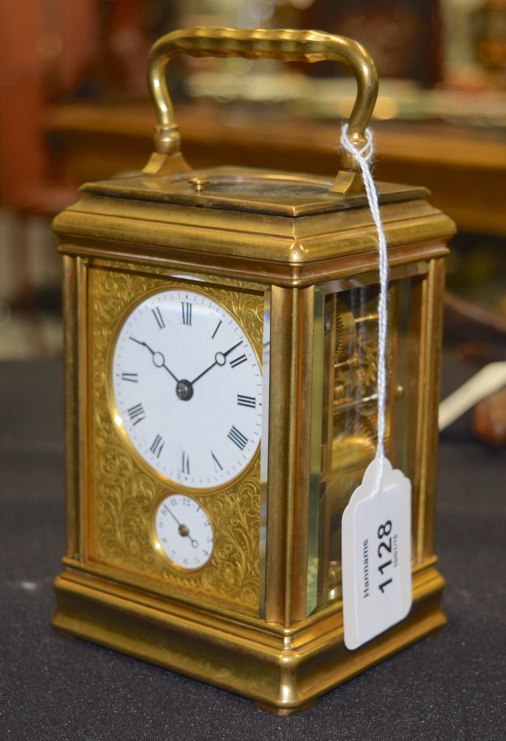 A FRENCH REPEATING BRASS CARRIAGE CLOCK with finely engraved brass face plate and multi dial. 16.5