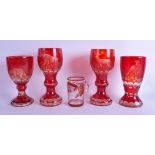 A GROUP OF FOUR BOHEMIAN RUBY GLASS GOBLETS together with a smaller engraved glass mug. Largest 20.5