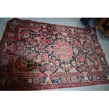 A LARGE RED GROUND POSSIBLY EAST TURKESTAN RUG, decorated with symbols and foliage. 234 cm x 147