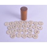 A RARE COLLECTION OF 18TH CENTURY CARVED BONE LETTERS within a treen jar and cover. Each letter 3 cm